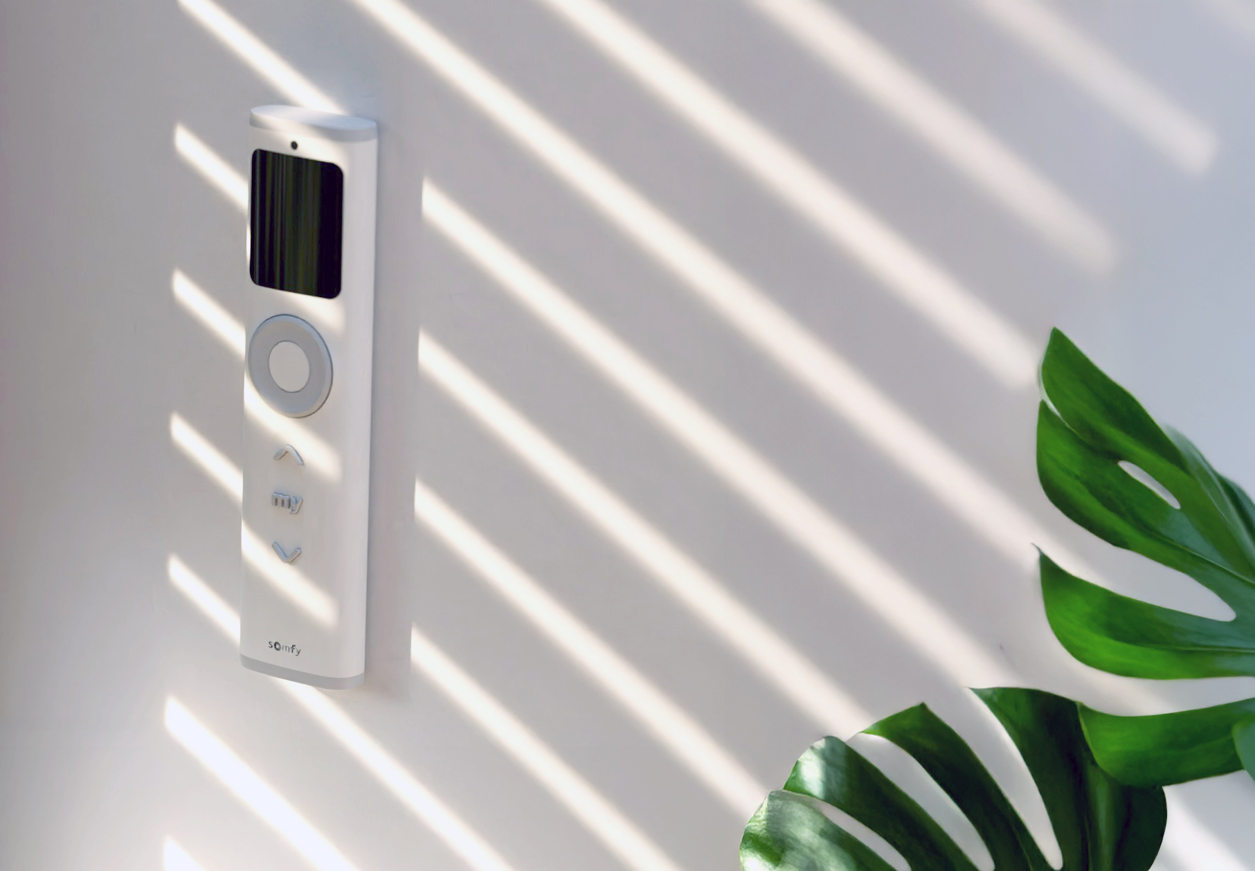 Biely ovládač na žalúzie Somfy Ysia Patio v držiaku na stene