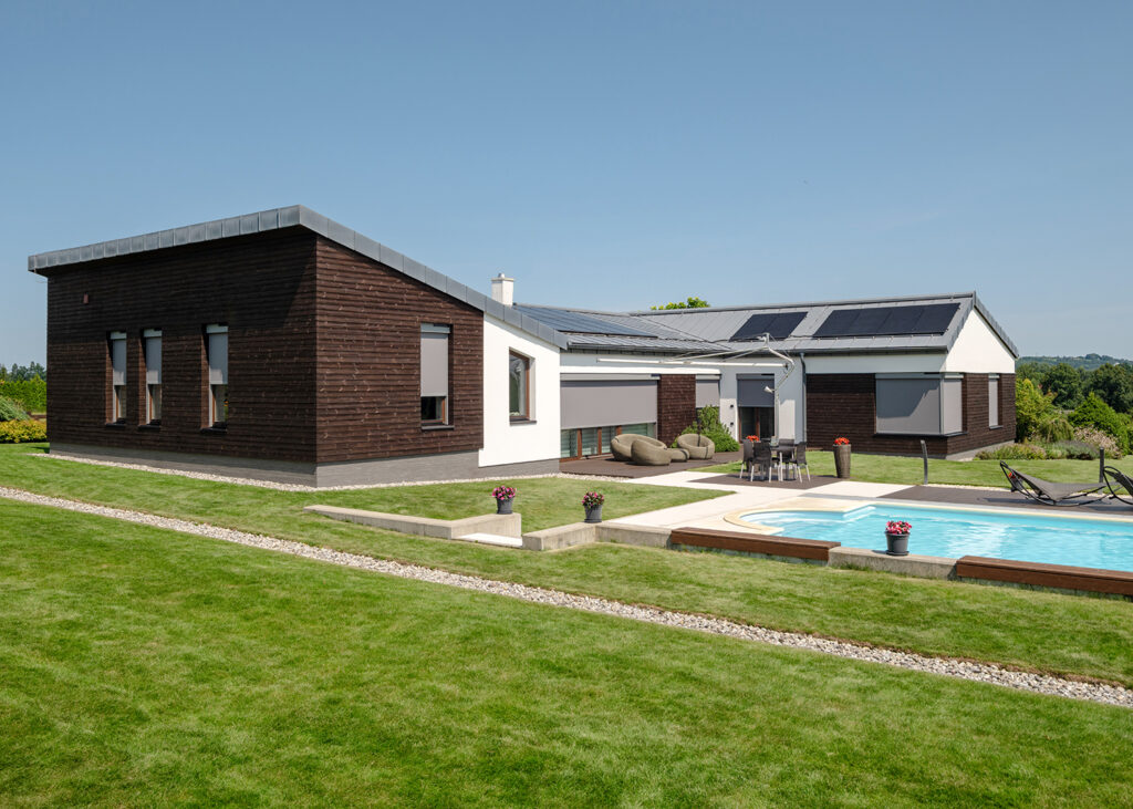 Dom s dreveným obkladom, bielou fasádou a screenovými roletami