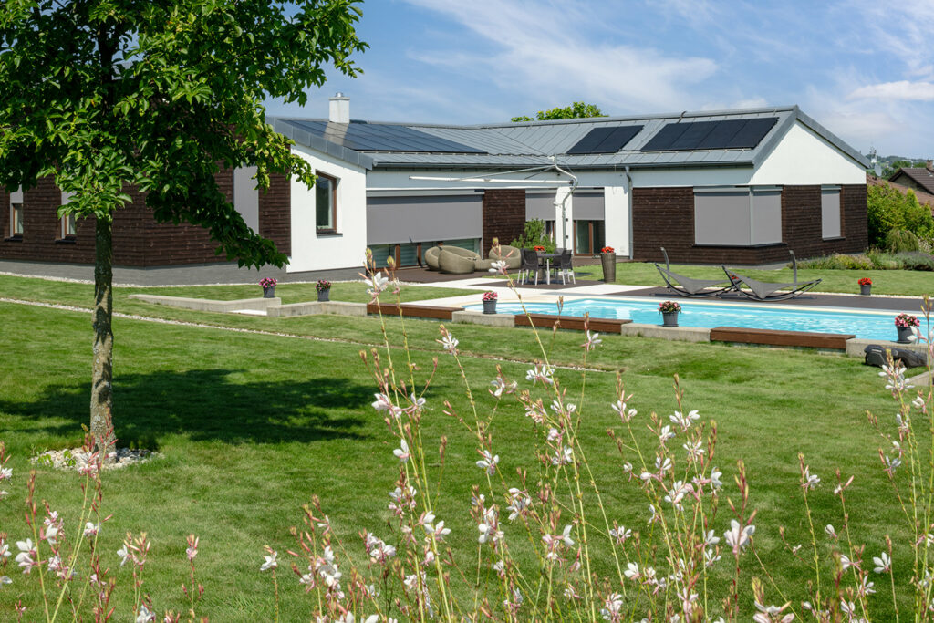 Moderný dom so solárnymi panelmi a solárnymi screenovými roletami