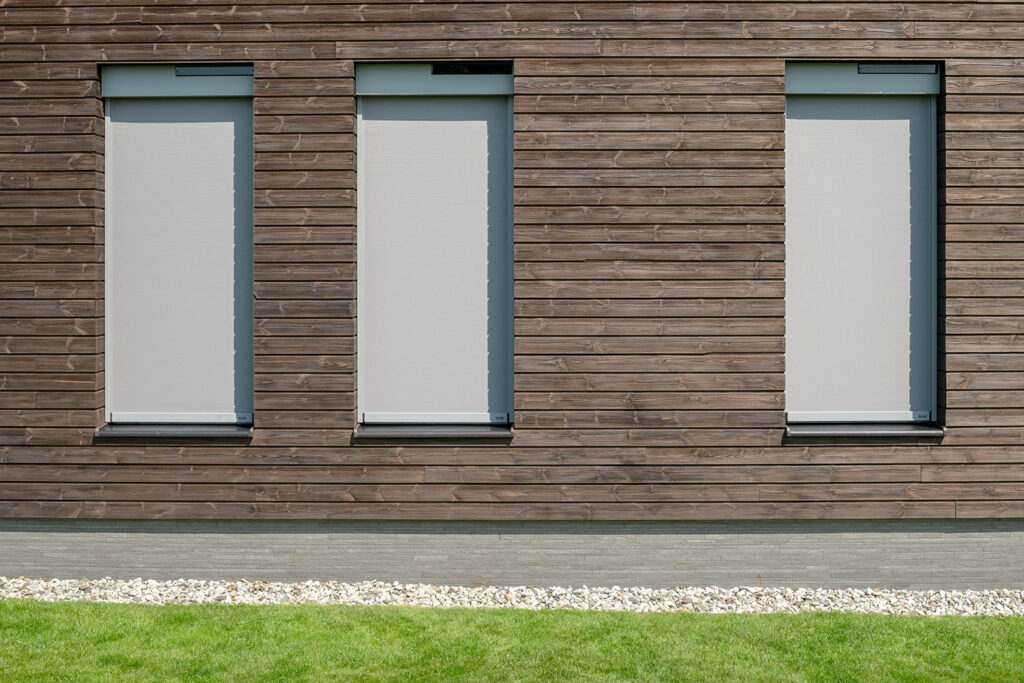 sivé solárne screeny na fasáde s dreveným obkladom