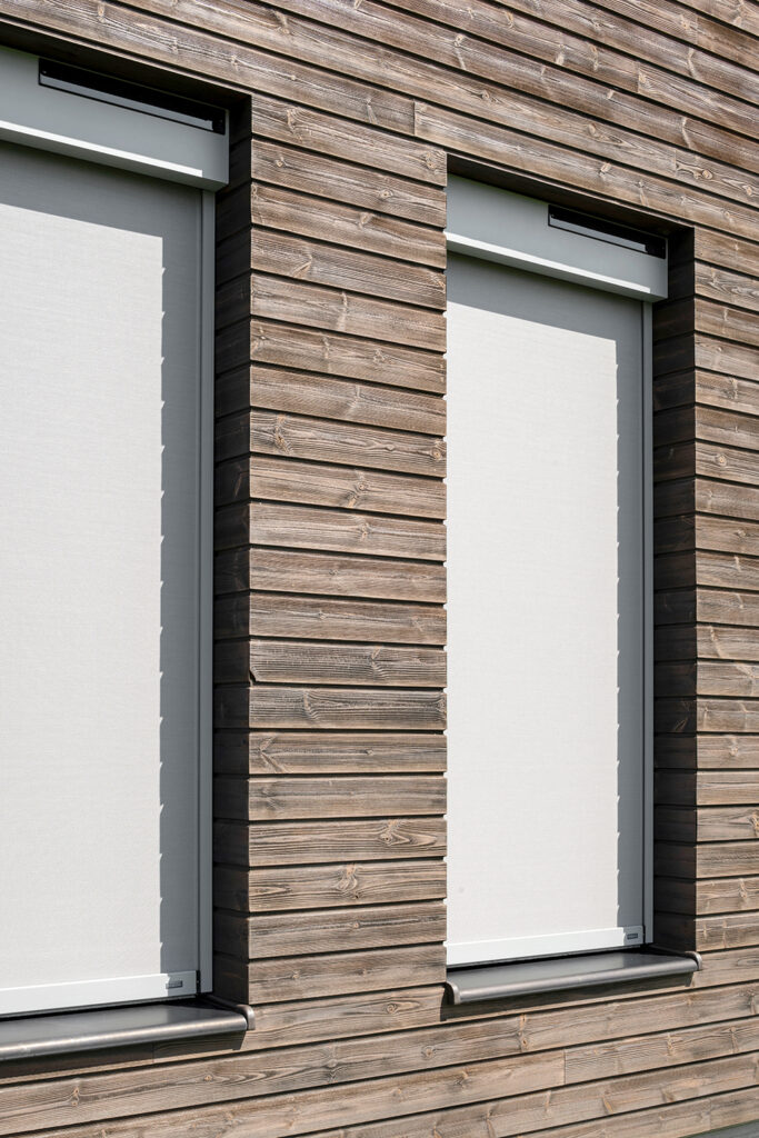 sivé solárne screeny na fasáde s dreveným obkladom