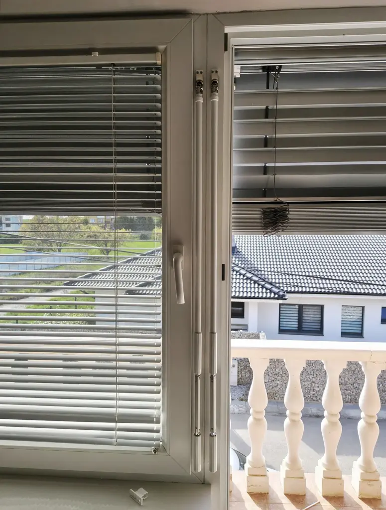 Kľuky pre ovládanie vonkajších žalúzií NEVA pripevnené na rám okna