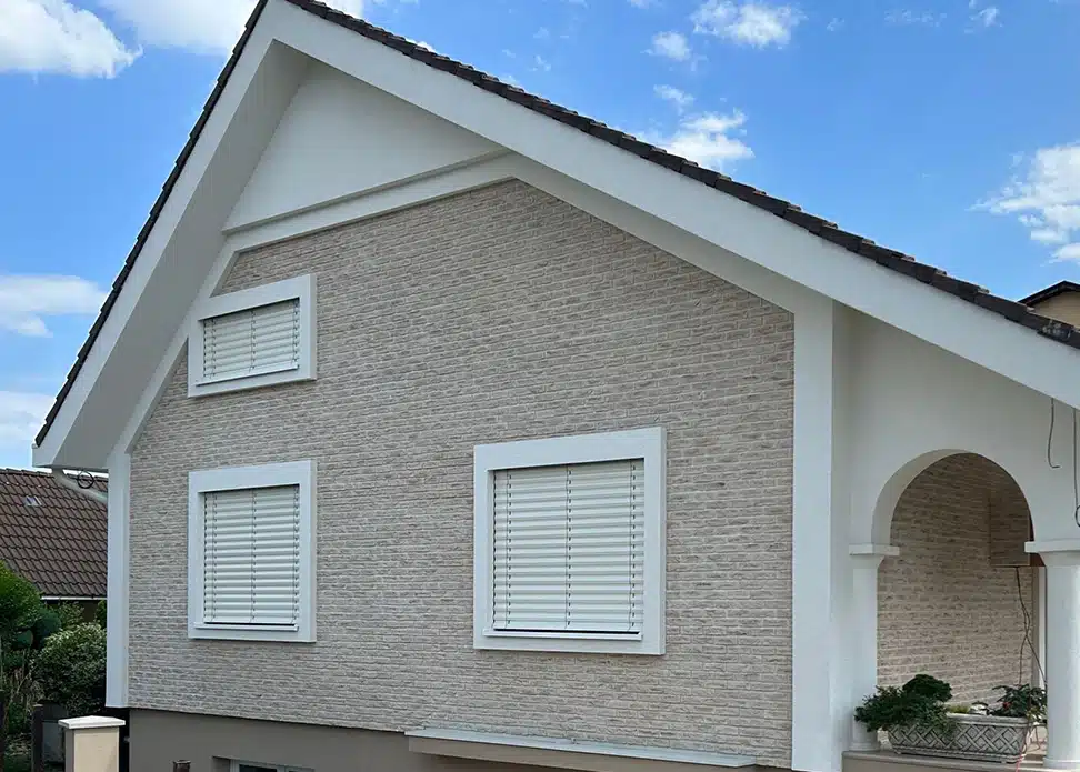 Biele vonkajšie žalúzie NEVA na dome s kamennou fasádou